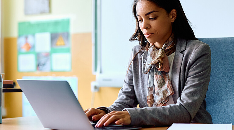 Teacher working on her laptop in the classroom