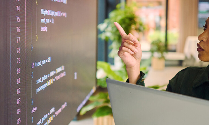 Person analyzing code on laptop