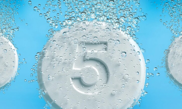 Tablets with the number five on them dropping into liquid and fizzing