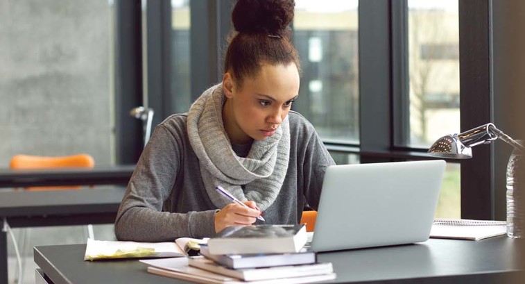 A woman works at her laptop