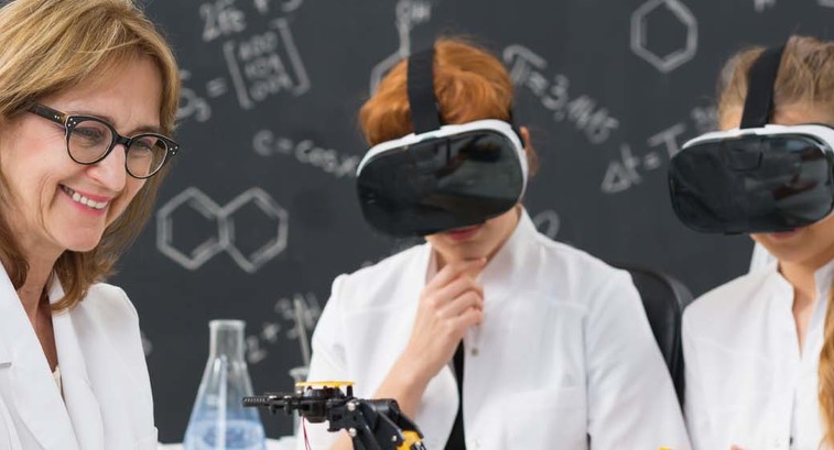 Two students wear VR headsets as their professor instructs