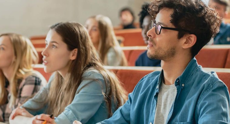 Students in a lecture hall listen intently