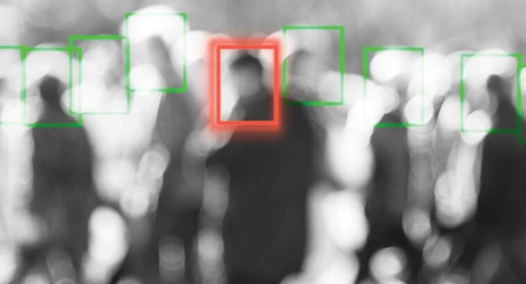 A blurred crowd of people whose faces are being scanned by an unseen camera
