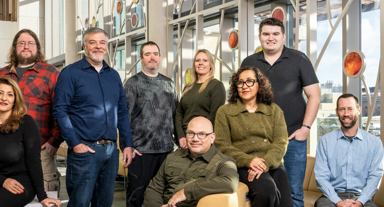A team of IT employees at the Universities of Wisconsin pose for a photo.