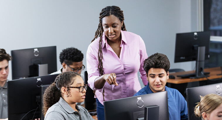 Teacher assisting students in computer lab