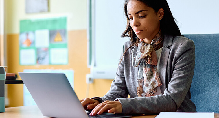 Teacher working on her laptop in the classroom