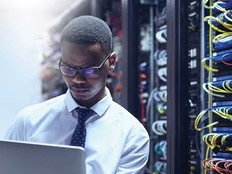 An IT worker on his laptop inside a data center