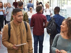 College students walk and talk in a crowded modern building