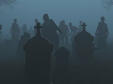 Silhouetted zombies rise from a foggy graveyard