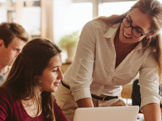 An instructor works with students in a classroom setting