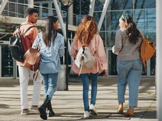 Rear angle photo of a group of students walking toward a campus building