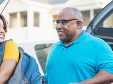 A student and and older adult unload a car during college move-in day