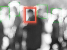 A blurred crowd of people whose faces are being scanned by an unseen camera
