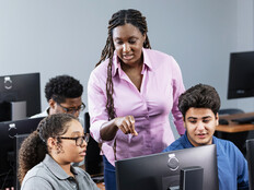 Teacher assisting students in computer lab