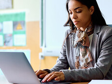 Teacher working on her laptop in the classroom