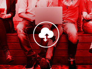 Legs dangle over a ledge as students use their laptops