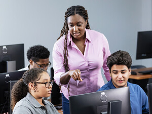 Teacher assisting students in computer lab