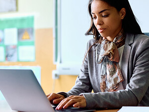 Teacher working on her laptop in the classroom