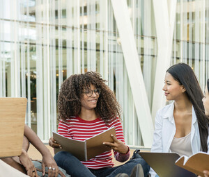 A group of students chat outside on a college campus