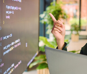 Person analyzing code on laptop