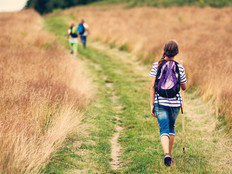Rural k-12 students on grass road with backpacks
