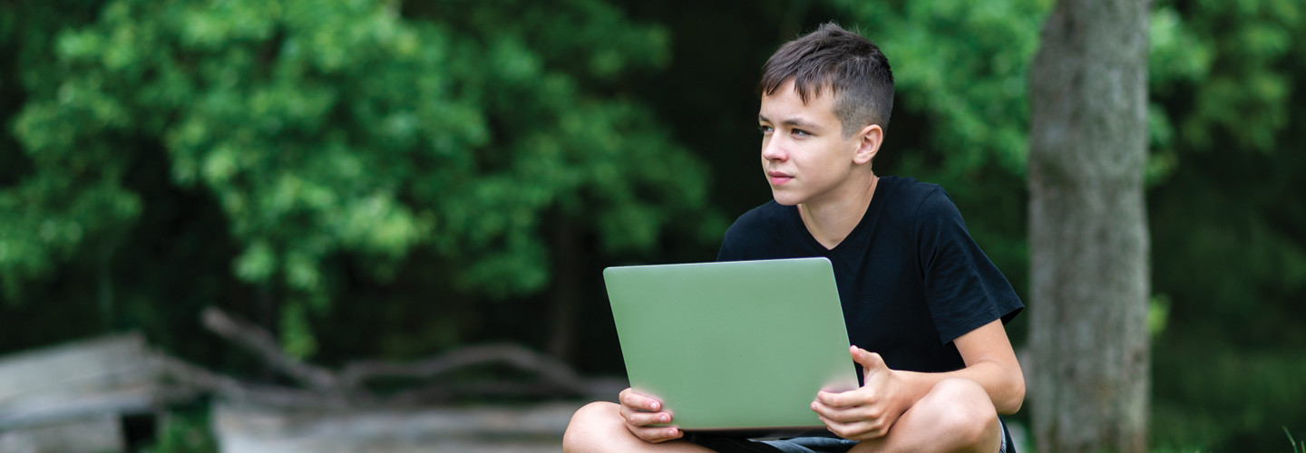 Student with laptop learning outside