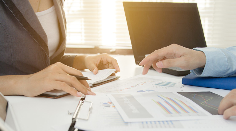 School administrators working on an audit at a desk 