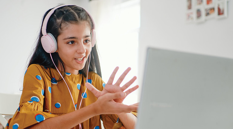student learning on computer with headphones