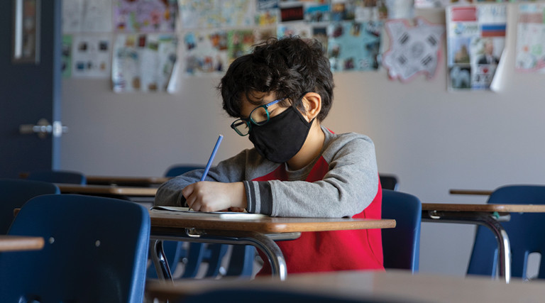 boy with mask in hybrid classroom