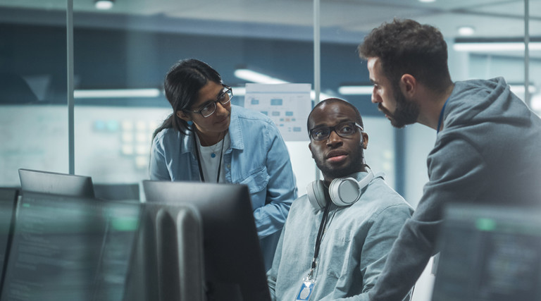 IT leaders discussing cybersecurity insurance around computers