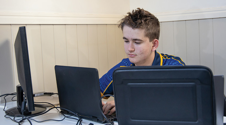 teenage boy using computer at home