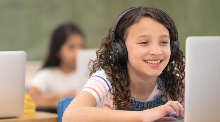Digital Transformation - students using laptops and headphones in classroom