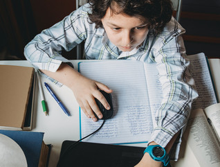 boy using laptop at home for school work