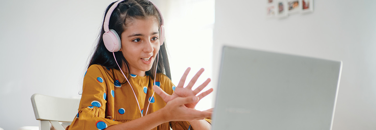 student learning on computer with headphones