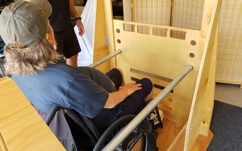 A man in a wheelchair inside the designed and assembled project