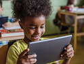 K-12 student using mobile tablet device in modern classroom