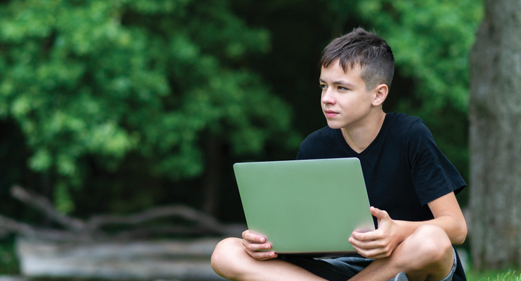 Student with laptop learning outside