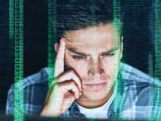 Man staring at computer with overlay of binary code