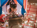 K–12 Kindergarten student learning in tent with toys and lights and tablet 