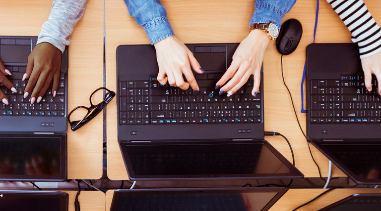 Students typing on laptops birds-eye view