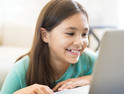 young girl on laptop smiling 