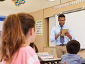 Male teacher standing in front of K-12 class - artificial intelligence support