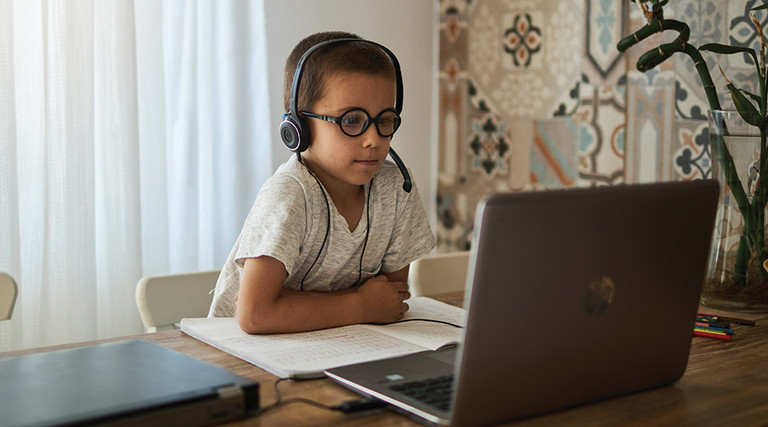 boy using laptop at home for learning