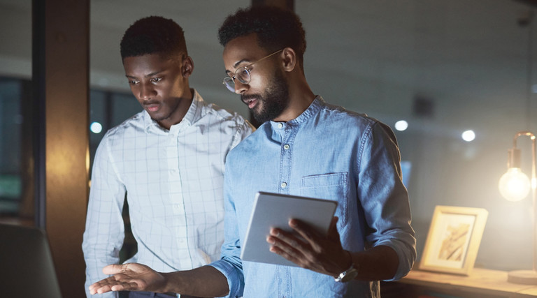 Two men with tablet and desktop computer looking at cybersecurity awareness