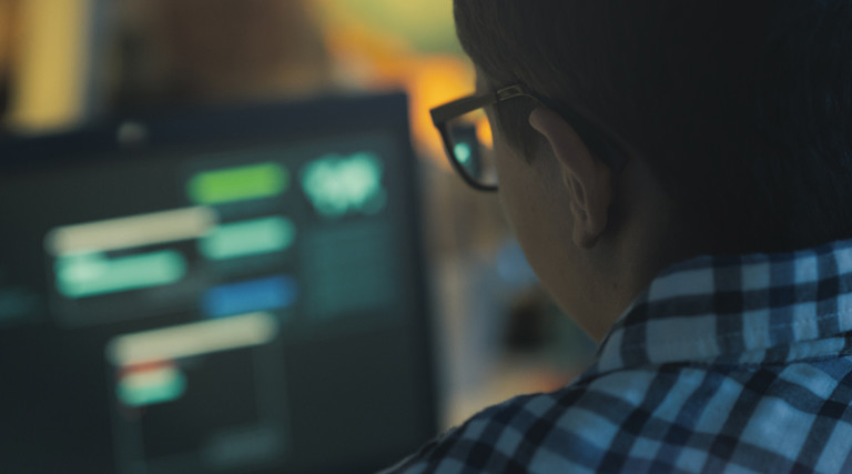 Student with glasses using computer for cyber attack