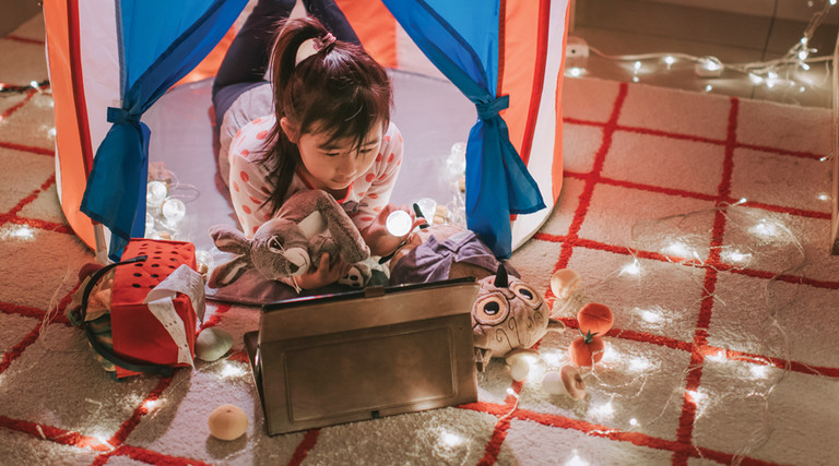 K–12 Kindergarten student learning in tent with toys and lights and tablet 