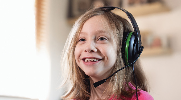 young girl smiling with gaming headset on 
