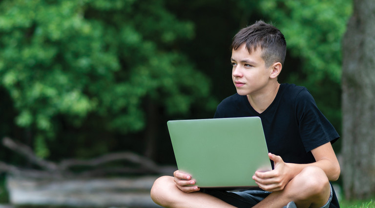 Student with laptop learning outside