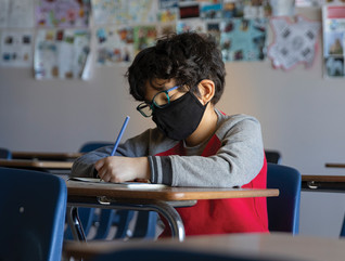 boy with mask in hybrid classroom