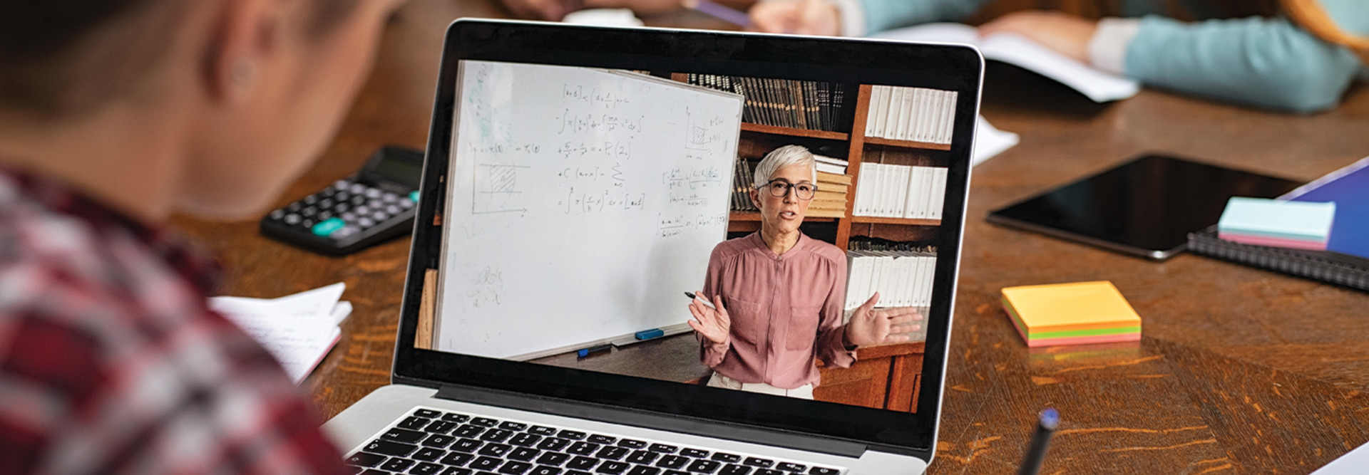 student watches lesson on laptop
